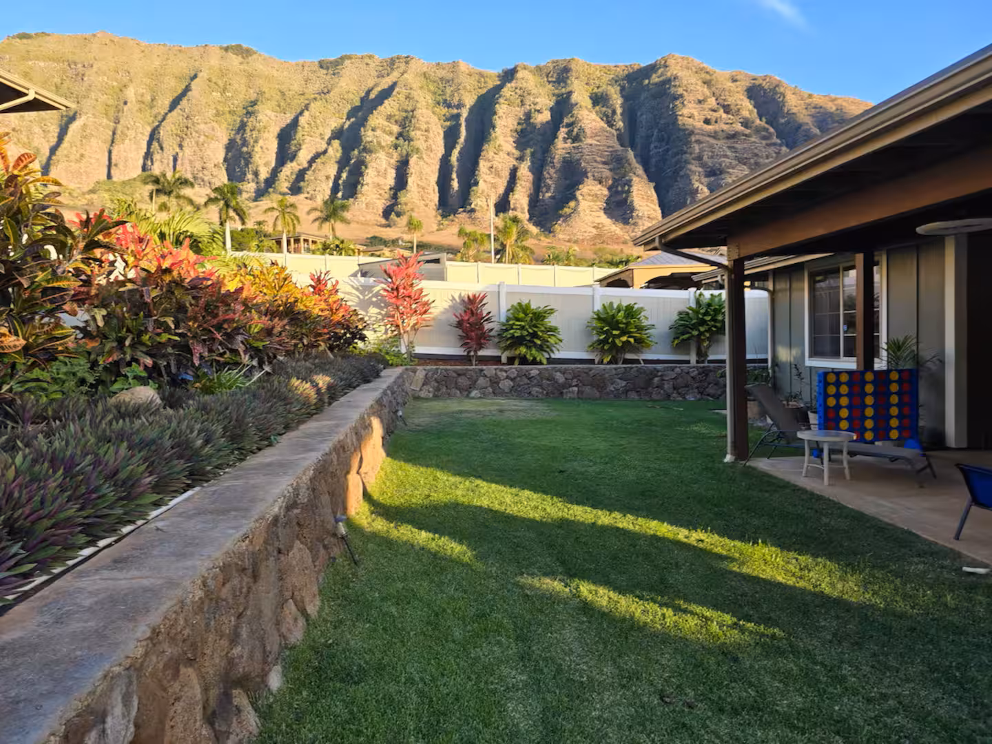 The back lawn and covered lanai with the steep green Waianae ridge filling the skyline