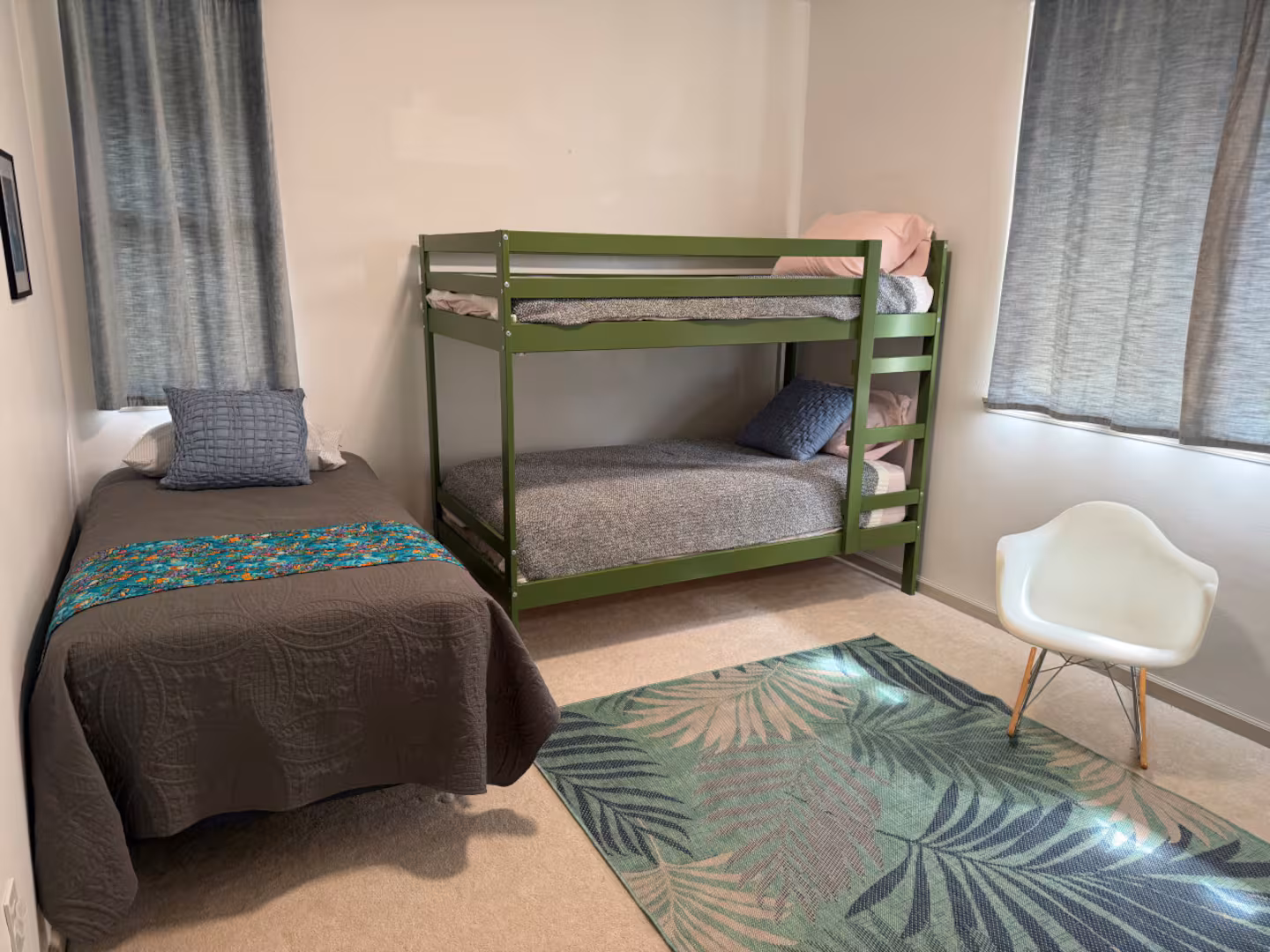 Third bedroom with a single bed and a green bunk bed, plus a palm-print rug