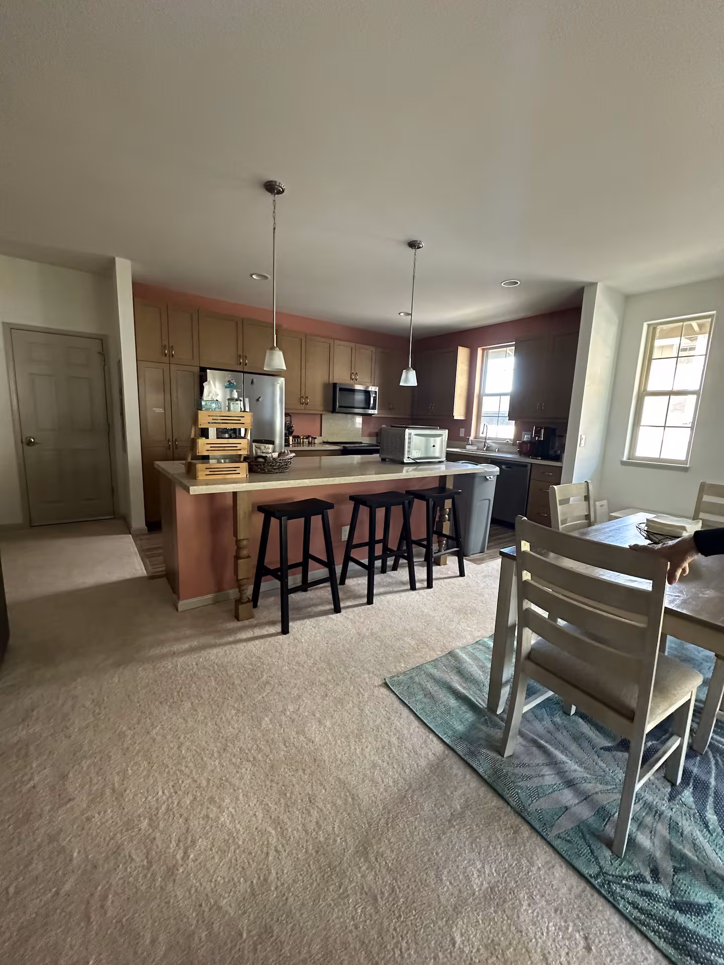 Open-plan kitchen and dining area with a breakfast bar, stools and a dining table