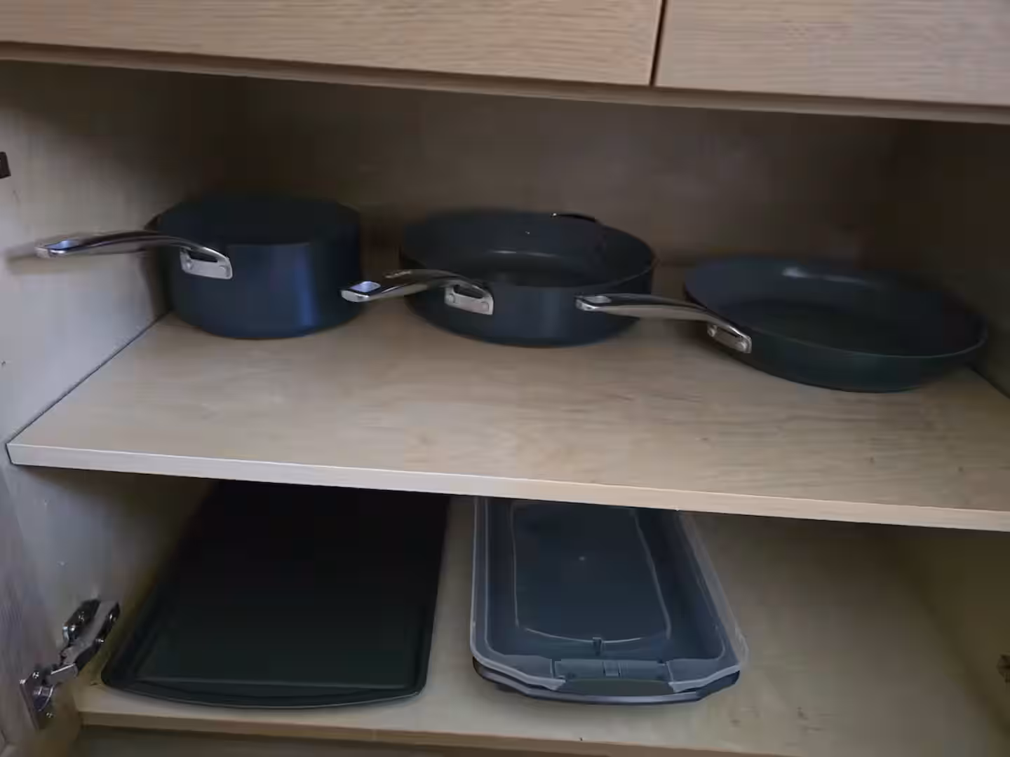 Cupboard with saucepans, frying pans and baking trays
