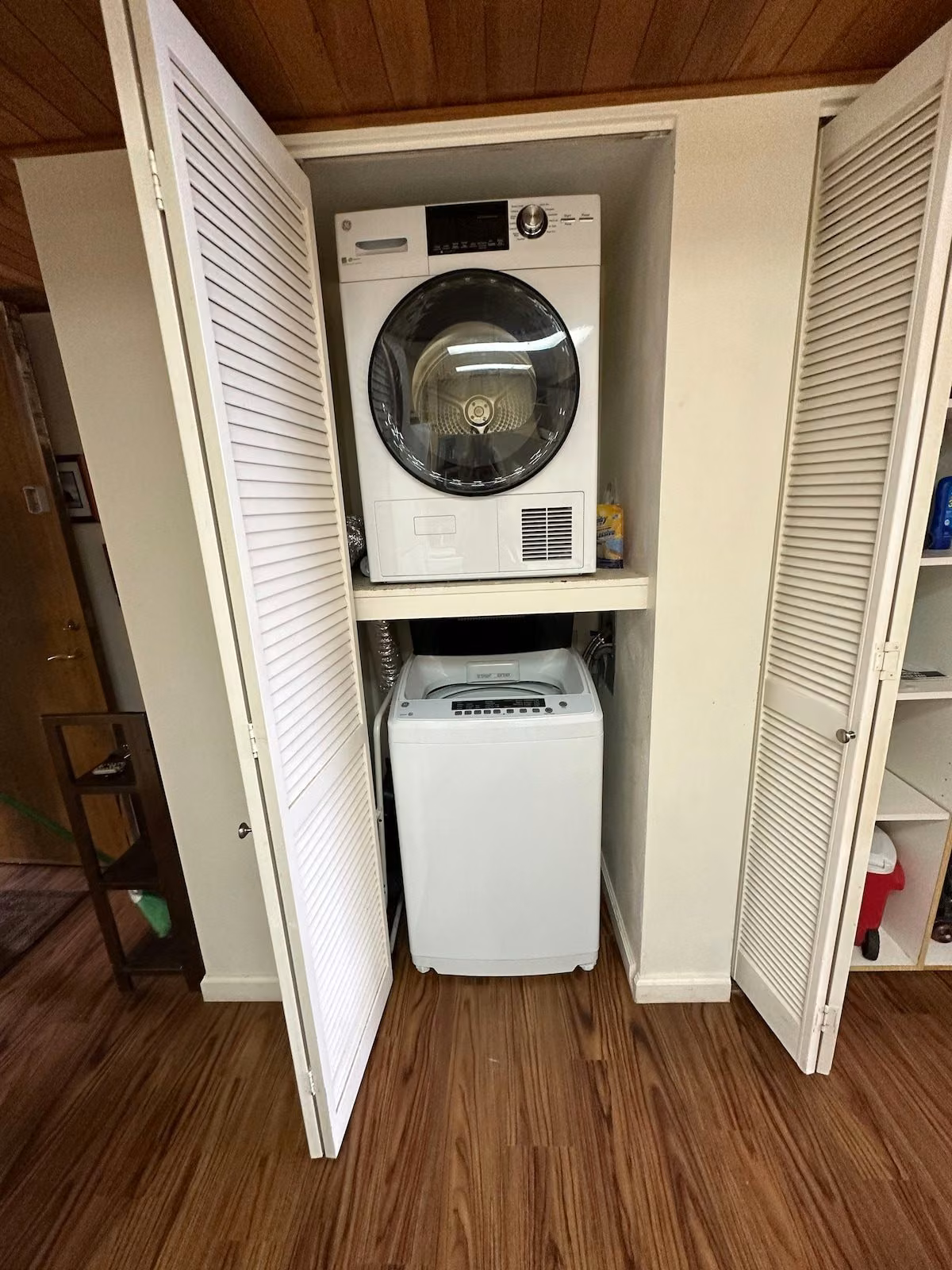 Stacked washer and dryer in a louvered closet inside the unit